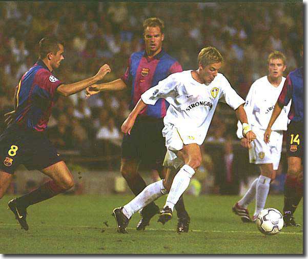Watched by Stephen McPhail, Alan Smith takes on Cocu and de Boer in Barcelona