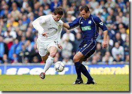 Harry Kewell takes on Blackburn's Lucas Neill at Elland Road