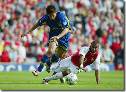 Harry Kewell rides the challenge of Arsenal's Ashley Cole