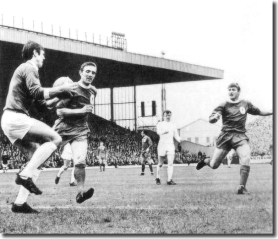 David Harvey collects the ball as Liverpool's Peter Thompson and Roger Hunt move in, while Bremner looks on during the Elland Road clash on May 4