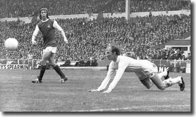 Jack Charlton stoops to head clear with Charlie George looking on
