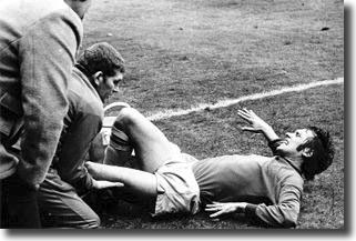 Burnley striker Frank Casper receives treatment after being ijured by Norman Hunter