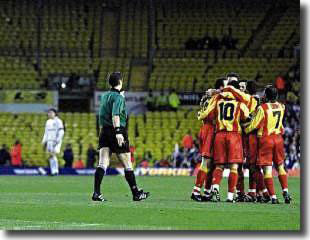 In front of the deserted section of Elland Road reserved for supporters who were subsequently banned, the Galatasaray players celebrate Hagi's early penalty