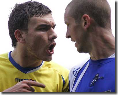 Robert Snodgrass has words with Millwall's Andy Frampton in the first leg of the Play Off semi final