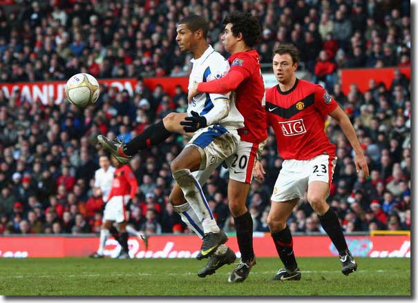 Jermaine Beckford holds up possession despite the best efforts of Fabio and Evans