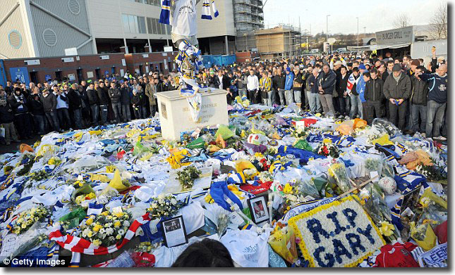 Supporters stand in hushed tribute to Speed outside the stadium before the game against Millwall