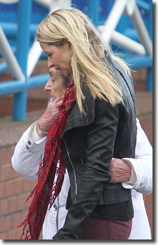 Speed's widow, Louise, is comforted as she surveys the tributes to her husband outside the stadium before the game against Millwall