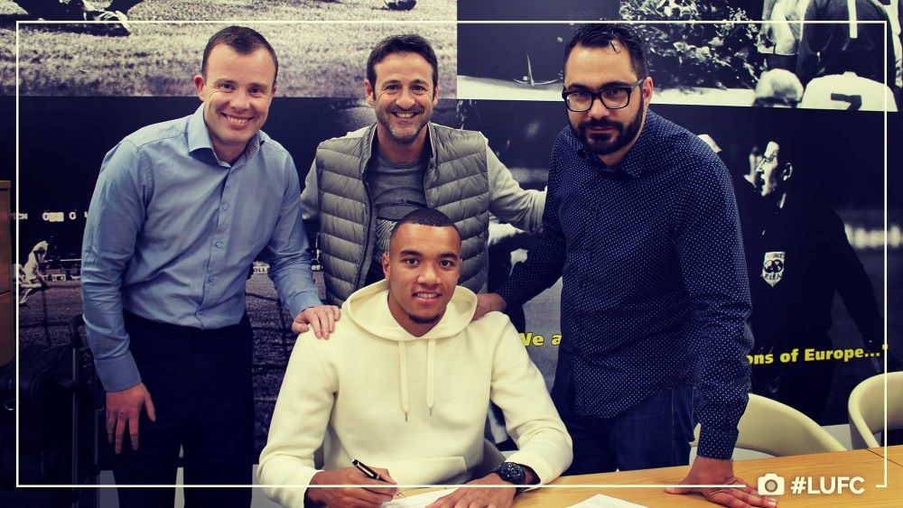 Angus Kinnear, Thomas Christiansen and Victor Orta look on as Jay-Roy Grot signs for Leeds