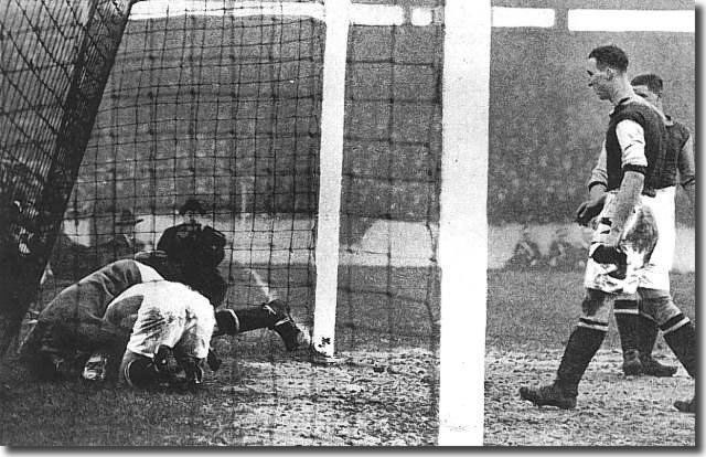 Tom Jennings charges West Ham goalkeeper Ted Hutton over his own line during an FA Cup tie at Upton Park in January 1930