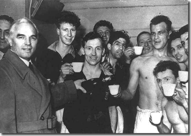 Dressing room celebrations following Leeds gaining promotion back to Division One 28 April 1956.  Manager Raich Carter pours a drink for John Charles with a youthful Jack Charlton at the back