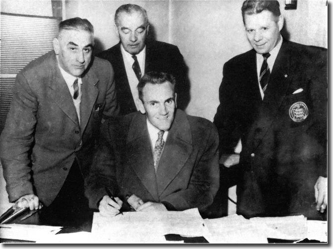 Bill Lambton (far right) watches as Don Revie signs for Leeds United