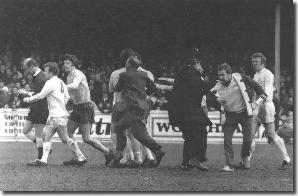 Billy Bremner remonstrates with referee Ray Tinkler while police and fans tussle following the "offside" goal by West Bromwich Albion