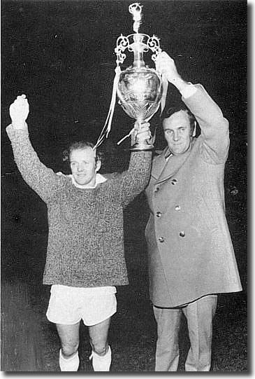 Billy Bremner and Don Revie lift the championship trophy after its presentation at the skipper's testimonial game with Sunderland