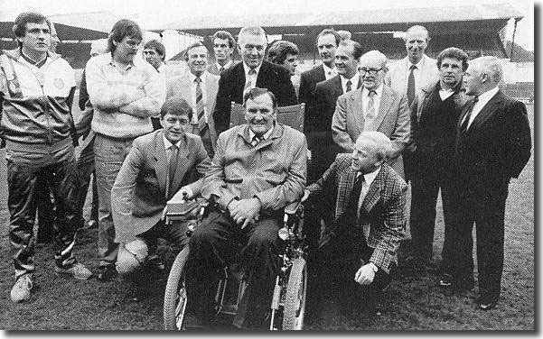 Revie, now crippled with Motor-Neurone disease, surrounded by ex-players following a reunion in 1988.  He is flanked by Allan Clarke and Billy Bremner with Norman Hunter and David Harvey on the left, Joe Jordan at the back, Mick Bates, Paul Madeley and Terry Cooper half hidden and Jack Charlton, Johnny Giles and Bobby Collins on the far right