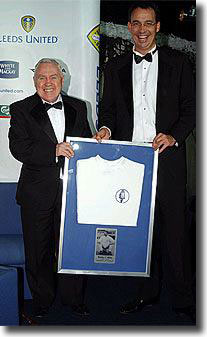 Bobby Collins receives a framed replica shirt from the 1960's after being inducted into the Leeds United Hall of Fame in December 2004