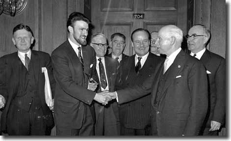 The PFA's Jimmy Hill shakes hands with League President Joe Richards during the negotiations on the maximum wage - Hardaker is on the left