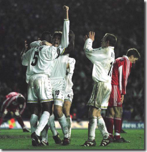 Delighted team mates mob Lucas Radebe after his late goal at Elland Road sees Leeds through against Spartak