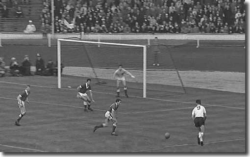 Alan Peacock moves onto the ball before unleashing an unstoppable shot from the right to beat Wales keeper Millington during a 4-0 victory in November 1962