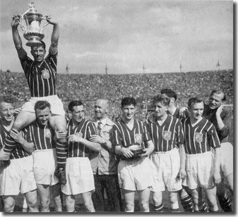 Don Revie hoists Man City captain Roy Paul with the FA Cup in 1956