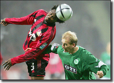 Roque Junior as a Milan player heads the ball clear of Wolfsburg's Miroslav Karhan